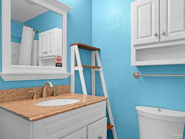 2701 E De Soto St, Pensacola, FL 32503 - full bath featuring vanity, toilet, a textured wall, and a shower with shower curtain
