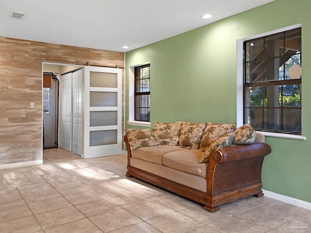 2701 E De Soto St, Pensacola, FL 32503 - tiled living area featuring recessed lighting, baseboards, an accent wall, and wooden walls