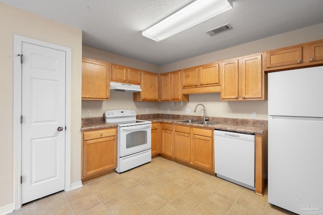 kitchen featuring white appliances, sink, and a textured ceiling