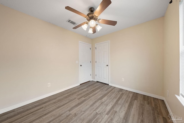 empty room featuring hardwood / wood-style floors and ceiling fan