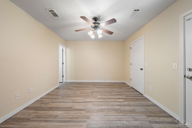 spare room with ceiling fan, light hardwood / wood-style flooring, and a textured ceiling