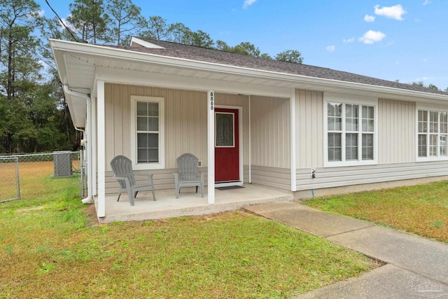 doorway to property featuring central AC unit, a yard, and a porch