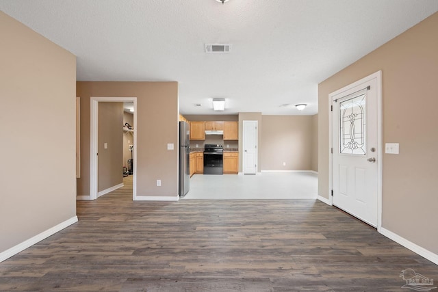 unfurnished living room with a textured ceiling and dark hardwood / wood-style flooring