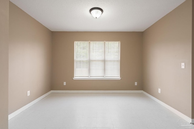 unfurnished room with a textured ceiling