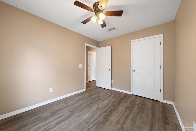 unfurnished bedroom featuring dark wood-type flooring and ceiling fan