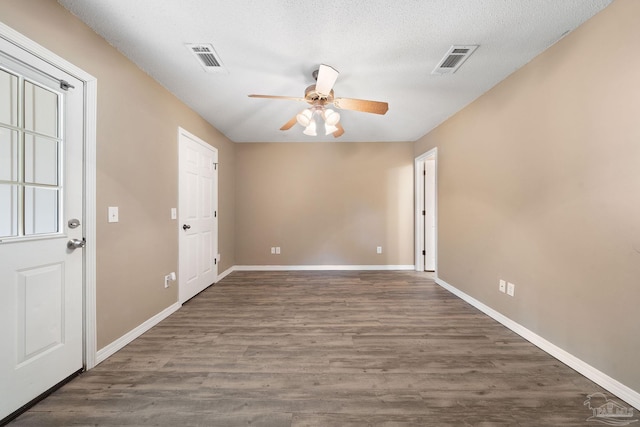 unfurnished room featuring ceiling fan, a textured ceiling, and dark hardwood / wood-style flooring