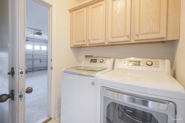 laundry area featuring washing machine and dryer and cabinets