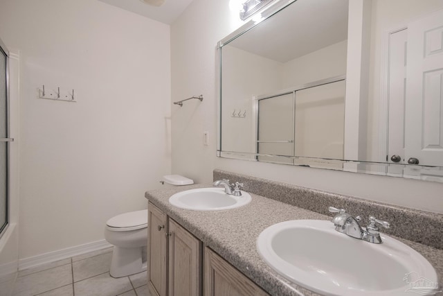 full bathroom with tile patterned flooring, vanity, bath / shower combo with glass door, and toilet