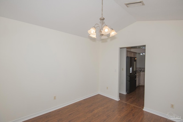 unfurnished room with vaulted ceiling, dark wood-type flooring, and a notable chandelier