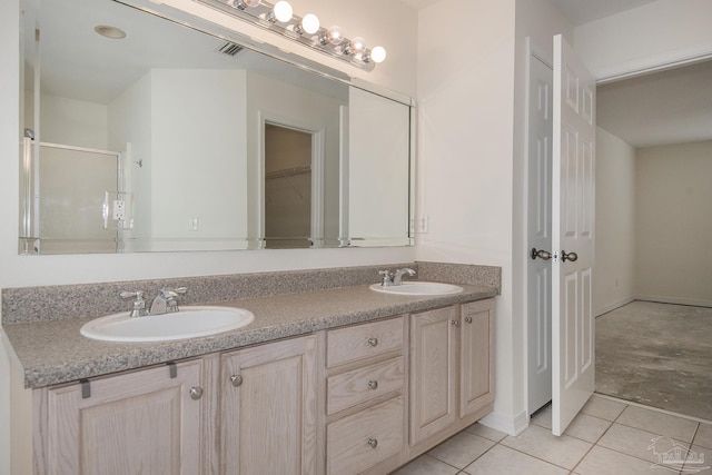 bathroom featuring tile patterned floors, a shower with door, and vanity