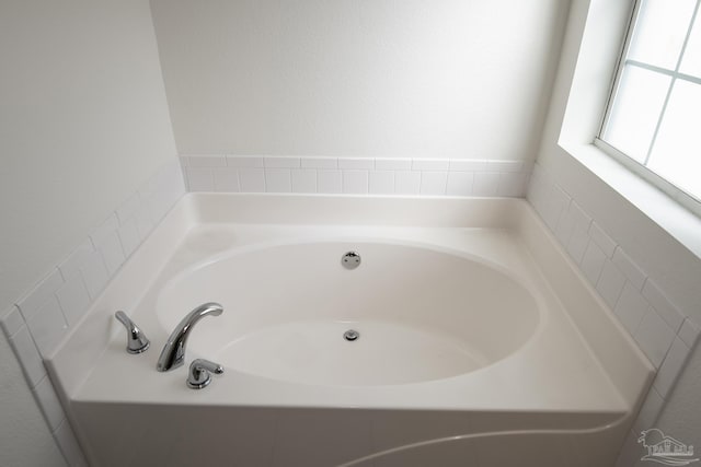 bathroom featuring a relaxing tiled tub