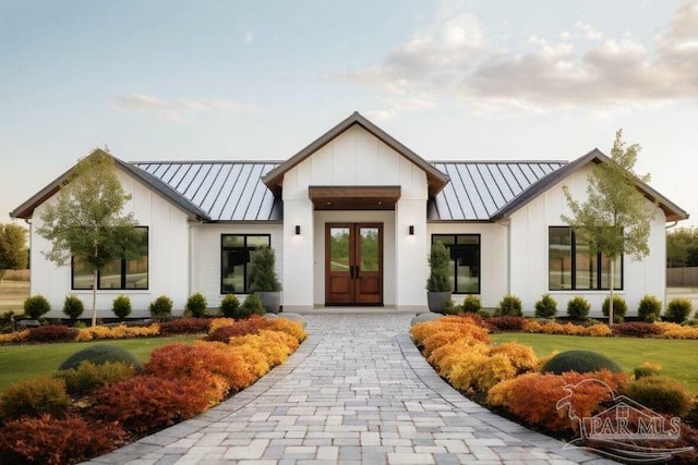 view of front of house with a standing seam roof, french doors, metal roof, and board and batten siding