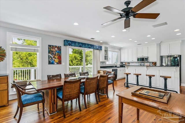 dining space with crown molding, light wood finished floors, a ceiling fan, recessed lighting, and visible vents