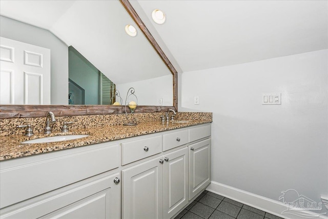 bathroom with a sink, tile patterned floors, baseboards, and double vanity