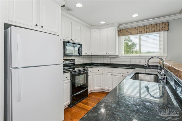 kitchen featuring visible vents, white cabinetry, a sink, dark stone countertops, and black appliances