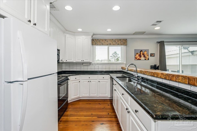 kitchen featuring visible vents, a sink, white cabinetry, and black appliances