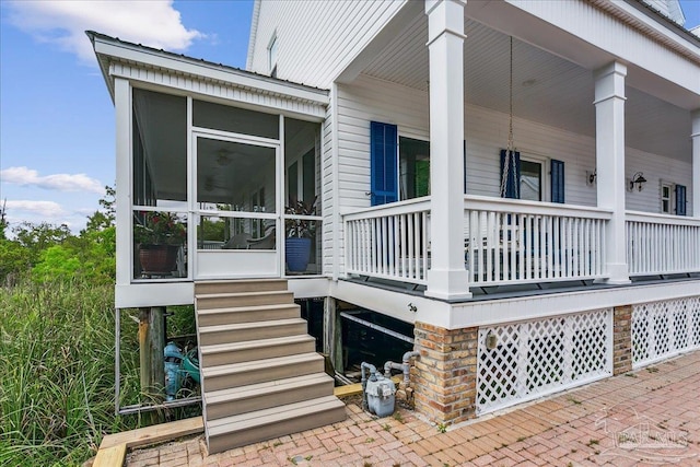 view of side of property with covered porch, stairs, and a sunroom