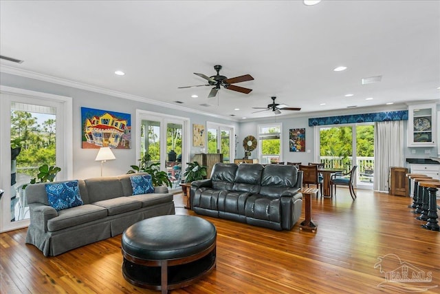 living room with a ceiling fan, recessed lighting, visible vents, ornamental molding, and hardwood / wood-style flooring
