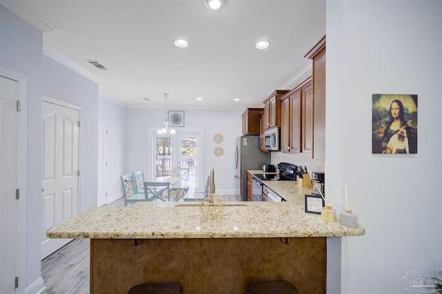 kitchen featuring crown molding, appliances with stainless steel finishes, kitchen peninsula, and light stone counters