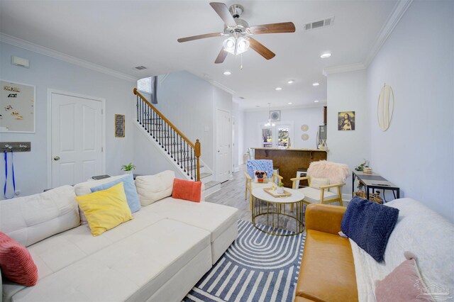 living room featuring light hardwood / wood-style floors, ceiling fan, and crown molding