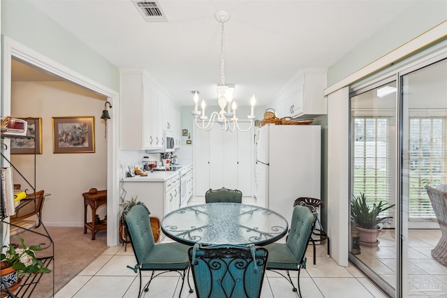 dining space with light colored carpet and an inviting chandelier