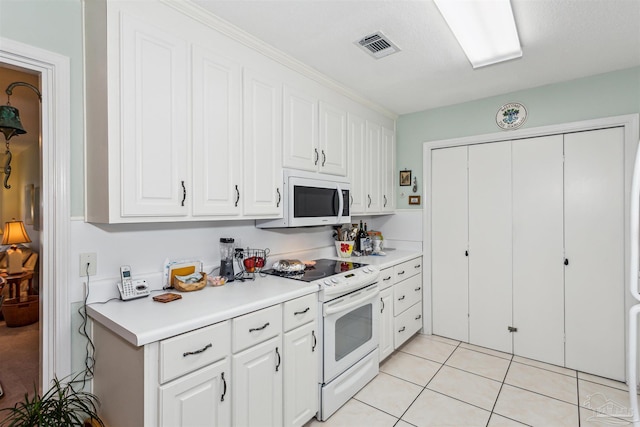 kitchen with white cabinets, white appliances, and light tile patterned floors