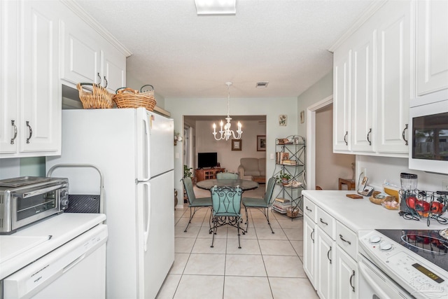 kitchen with white cabinets, hanging light fixtures, a chandelier, light tile patterned flooring, and white appliances