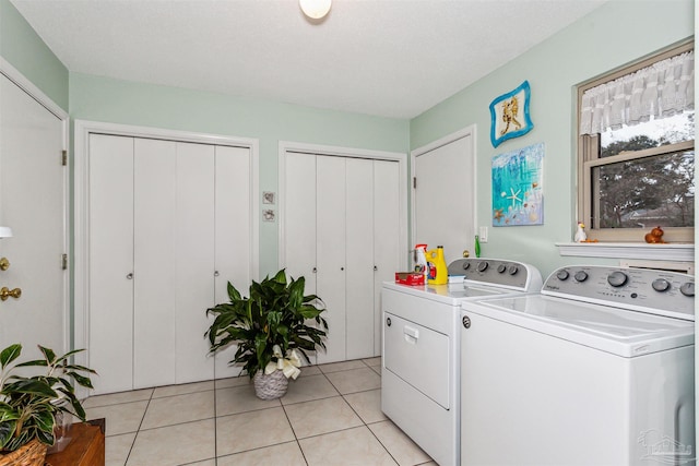 laundry area with light tile patterned flooring and washer and dryer