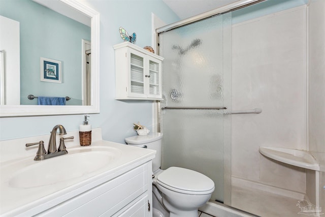 bathroom featuring walk in shower, vanity, and toilet