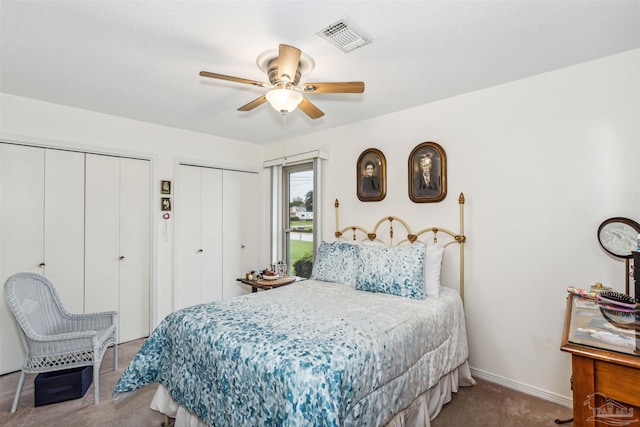 bedroom featuring multiple closets, light carpet, and ceiling fan