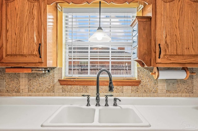 4420 Bellwood Cir, Pace, FL 32571 - kitchen with brown cabinetry, light countertops, and tasteful backsplash