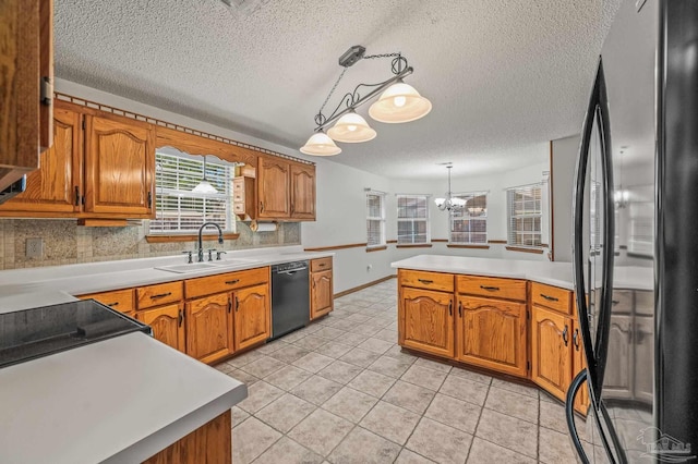 4420 Bellwood Cir, Pace, FL 32571 - kitchen featuring freestanding refrigerator, black dishwasher, a textured ceiling, brown cabinets, and a peninsula