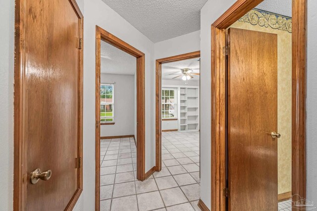 4420 Bellwood Cir, Pace, FL 32571 - hallway with a textured ceiling and light tile patterned floors