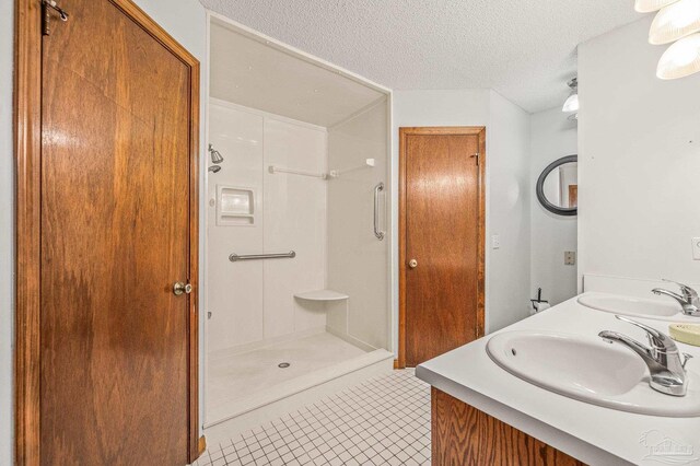 4420 Bellwood Cir, Pace, FL 32571 - full bath featuring tile patterned floors, double vanity, a shower stall, and a textured ceiling