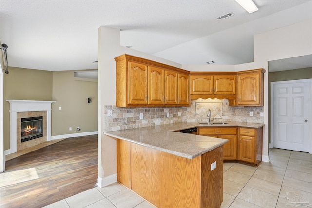 5833 Pebble Ridge Dr, Milton, FL 32583 - kitchen featuring light countertops, decorative backsplash, brown cabinetry, a peninsula, and light tile patterned floors