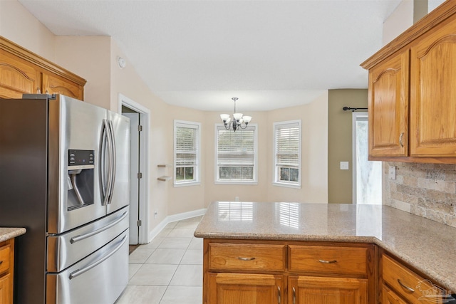 5833 Pebble Ridge Dr, Milton, FL 32583 - kitchen with stainless steel fridge with ice dispenser, a peninsula, light tile patterned floors, backsplash, and a chandelier