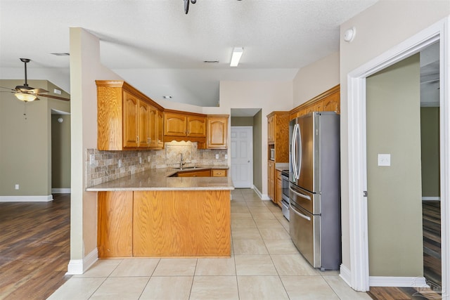 5833 Pebble Ridge Dr, Milton, FL 32583 - kitchen featuring stainless steel appliances, ceiling fan, a peninsula, vaulted ceiling, and brown cabinets