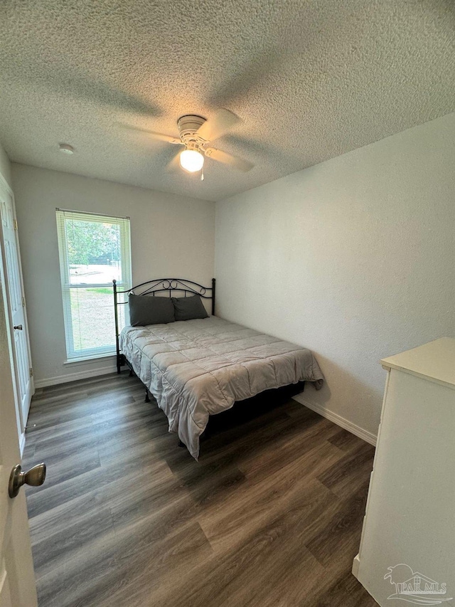 bedroom featuring a textured ceiling, dark hardwood / wood-style floors, and ceiling fan