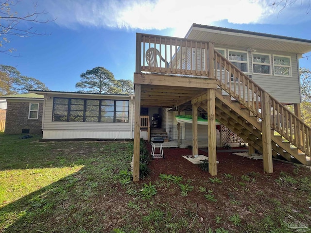 rear view of house with a lawn and a wooden deck