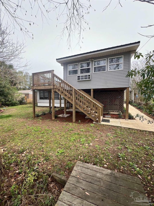 rear view of house with a lawn, a wooden deck, and a patio area