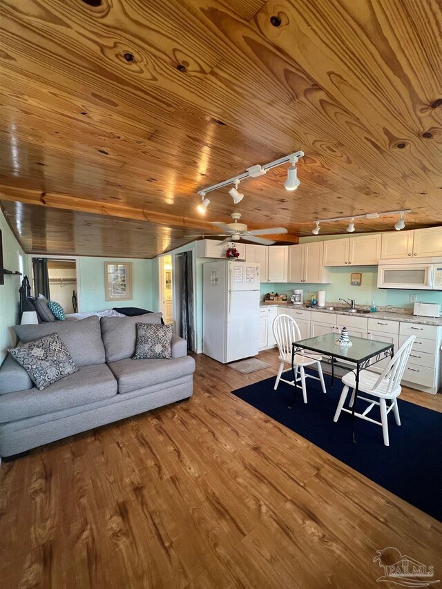 living room with light hardwood / wood-style floors, sink, and wooden ceiling