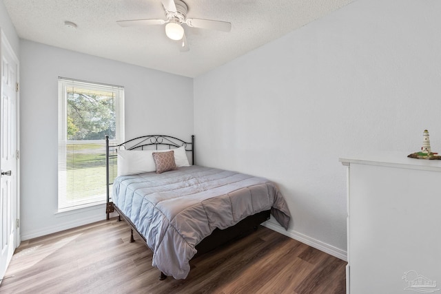 bedroom with ceiling fan, a textured ceiling, and hardwood / wood-style floors