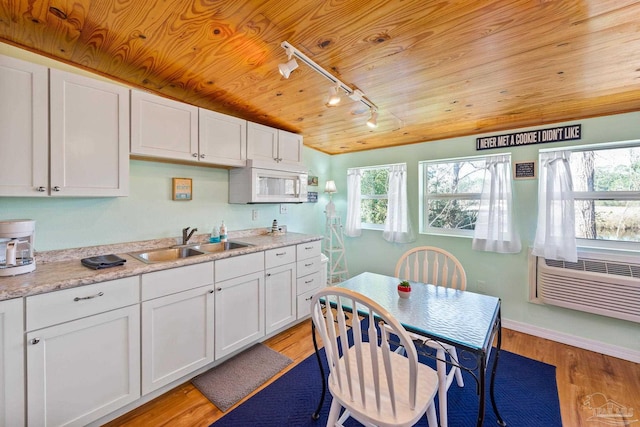 kitchen with white cabinets, light hardwood / wood-style floors, sink, and wood ceiling