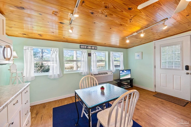 dining room with wood ceiling, track lighting, cooling unit, and light hardwood / wood-style flooring