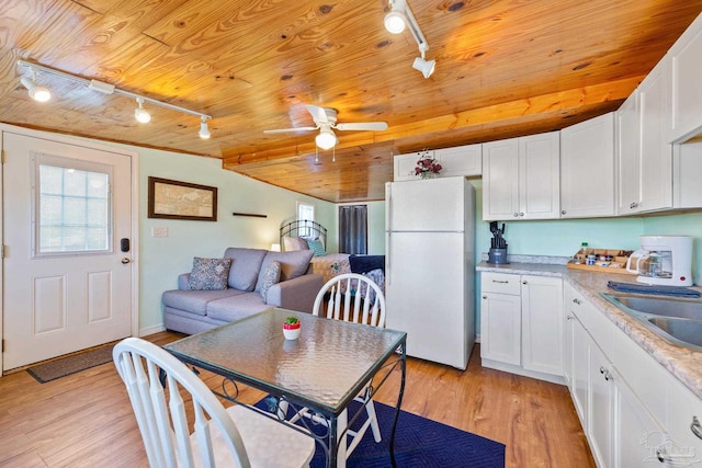 kitchen featuring white fridge, sink, white cabinets, and light wood-type flooring