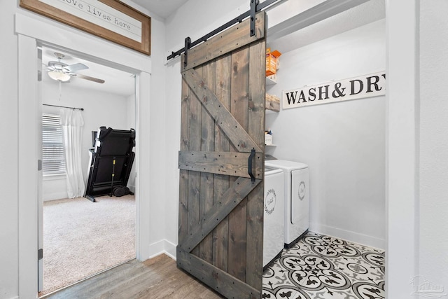 5722 Conley Ct, Pace, FL 32571 - laundry room with independent washer and dryer, a barn door, ceiling fan, wood finished floors, and baseboards