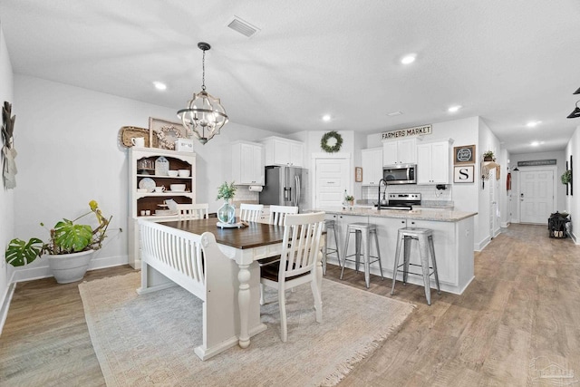 5722 Conley Ct, Pace, FL 32571 - dining room featuring light wood-style flooring, a chandelier, baseboards, and recessed lighting
