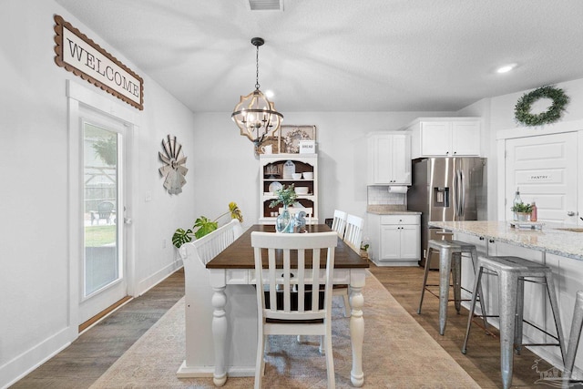 5722 Conley Ct, Pace, FL 32571 - dining space featuring a chandelier, dark wood-type flooring, baseboards, and a textured ceiling