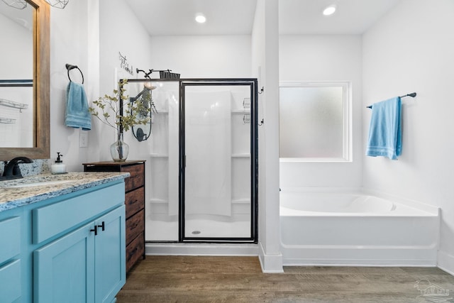 5722 Conley Ct, Pace, FL 32571 - bathroom featuring wood finished floors, a stall shower, vanity, a garden tub, and baseboards