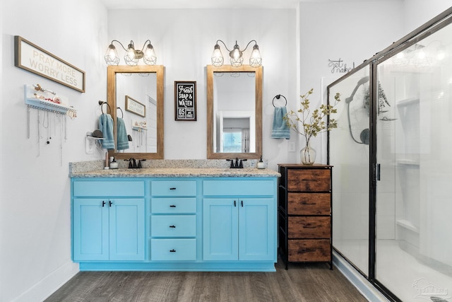 5722 Conley Ct, Pace, FL 32571 - full bathroom featuring wood finished floors, a shower stall, double vanity, and baseboards